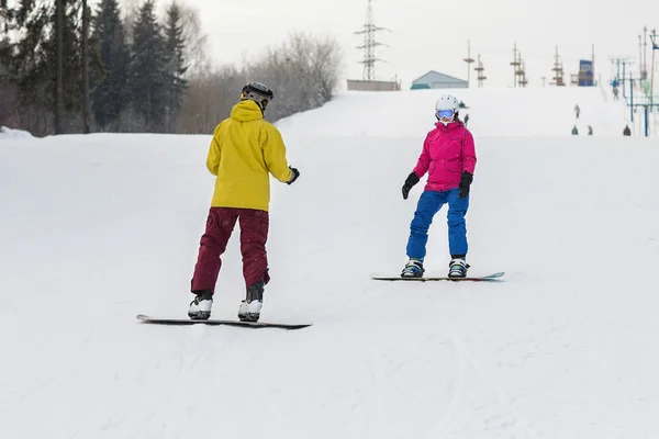 Casal jovem snowboarders deslizar para baixo — Fotografia de Stock