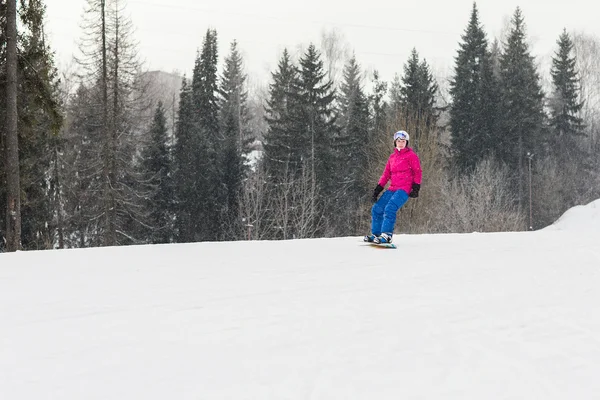 Mulher snowboarder nas encostas dia de inverno gelado — Fotografia de Stock
