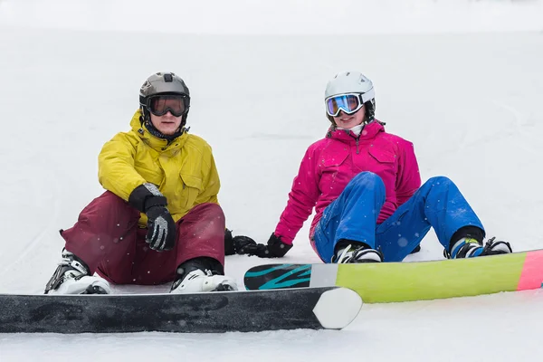 Ungt par sitter på sluttningen snowboardåkare — Stockfoto
