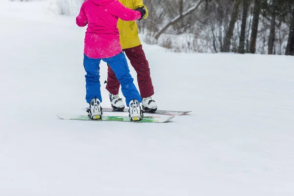 Jong koppel snowboarders dia naar beneden — Stockfoto