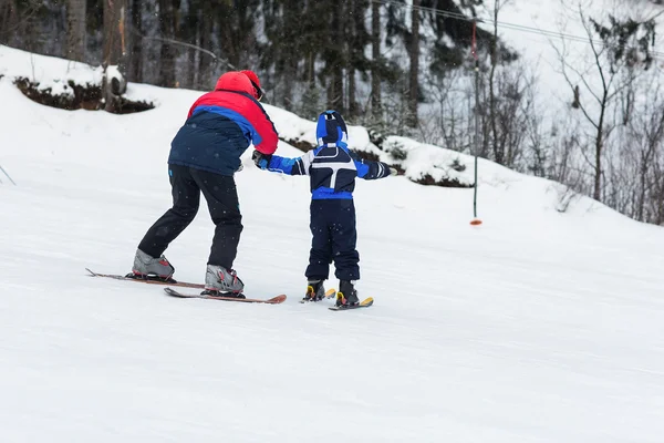 Skilehrer bringen einem Kind das Skifahren bei — Stockfoto