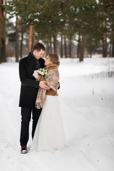 Young couple newlyweds walking in a winter forest in the snow. — Stock Photo, Image