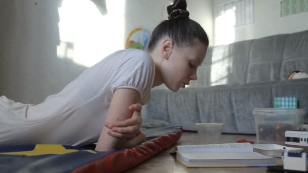 Mãe-criança lendo um livro. Uma criança joga no jogo . — Vídeo de Stock