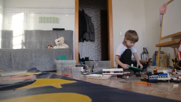 Un niño juega en el constructor y juguetes — Vídeos de Stock