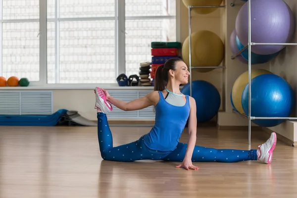 年轻的健身女人做伸展在健身房 — 图库照片
