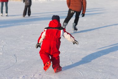 Happy child skating in winter at the rink