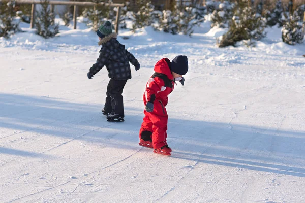 Patinaje infantil feliz en invierno en la pista —  Fotos de Stock
