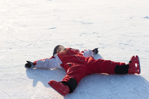 Boy does the angel on the winter ice — Zdjęcie stockowe