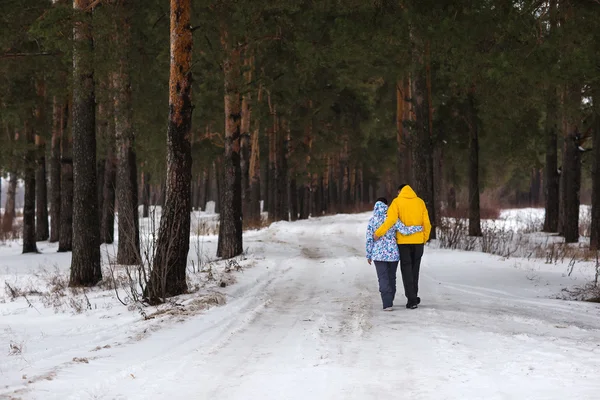 Pareja joven en el bosque de invierno . — Foto de Stock