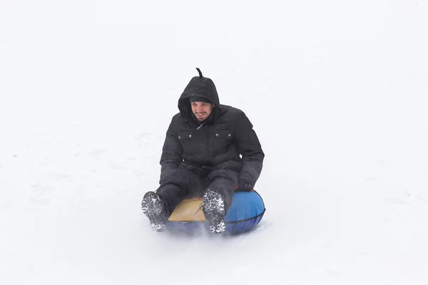 Hombre joven con paseos en montaña rusa en el invierno — Foto de Stock