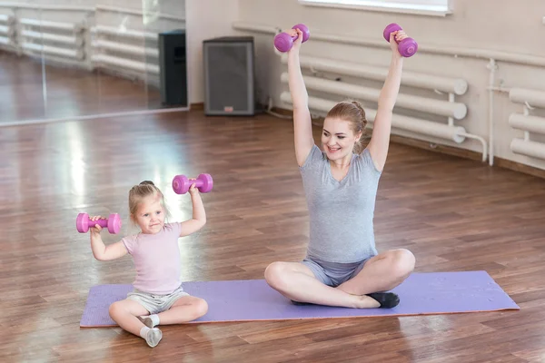 Mujer embarazada con su hija haciendo gimnasia — Foto de Stock