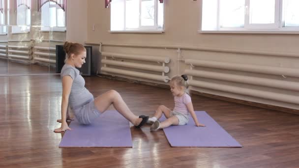 Gravid kvinna med dottern första kid gör gymnastik — Stockvideo