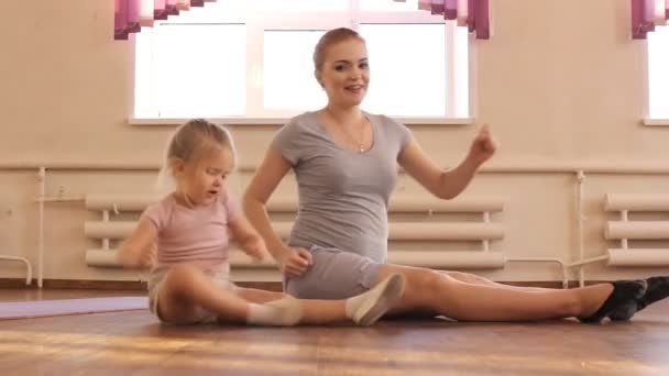 Mujer embarazada con su primera hija haciendo gimnasia — Vídeo de stock