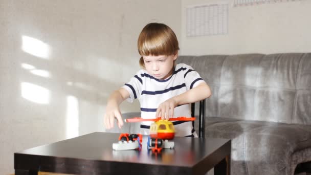 Menino brincando com lotes de blocos de plástico colorido interior — Vídeo de Stock