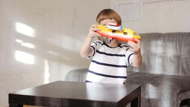 Jongen met veel kleurrijke kunststof blokken binnen spelen — Stockvideo