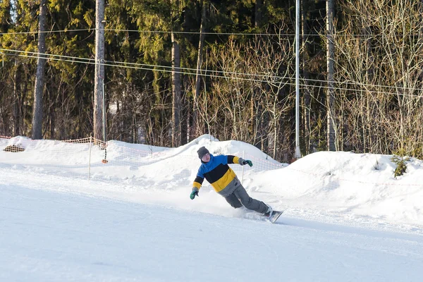 Snowboarder poniendo vueltas en la pista de esquí — Foto de Stock