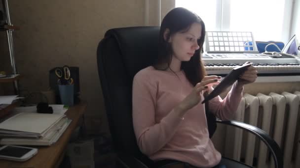 Egy széken ülve a táblaszámítógépen dolgozó nő — Stock videók