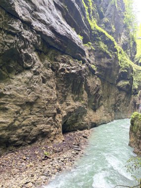 Dar bir dağ geçidinin ıslak taş duvarlarının unutulmaz manzarası Partnach dağ deresinin amansız akıntısı tarafından delindi..