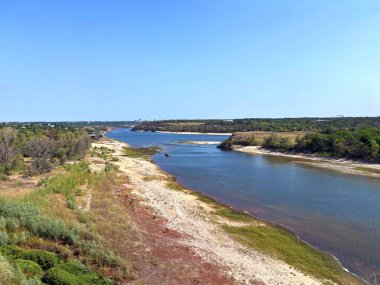 Dinyeper nehir yatağının şaşırtıcı manzarası. Etrafı yoğun sedir ve sazlıklarla çevrili. Güneşli bir yaz gökyüzünün arka planında Baida adasını yıkıyorlar..