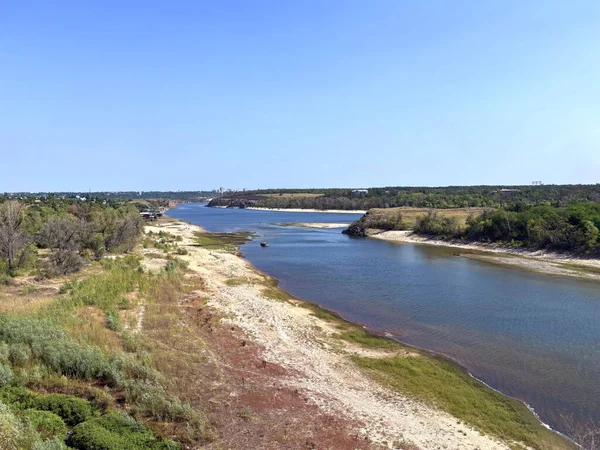 Dinyeper nehir yatağının şaşırtıcı manzarası. Etrafı yoğun sedir ve sazlıklarla çevrili. Güneşli bir yaz gökyüzünün arka planında Baida adasını yıkıyorlar..