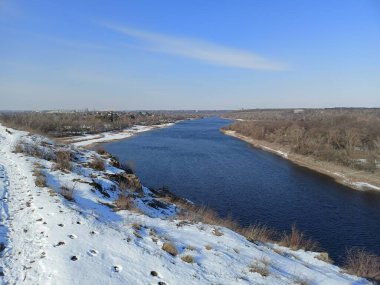 Açık bir gökyüzünün mavi tonlarıyla Dinyeper 'in soğuk kış günündeki su yüzeyinin büyüleyici doğal bir manzarası..