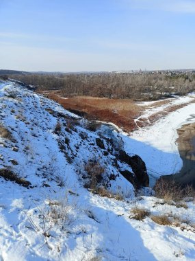 Karla kaplı Dinyeper kıyılarının yukarısından gelen panorama mavi ufkun arka planında parlak, soğuk bir güneşin ışınları altında.