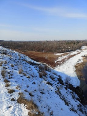 Karla kaplı Dinyeper kıyılarının yukarısından gelen panorama mavi ufkun arka planında parlak, soğuk bir güneşin ışınları altında.