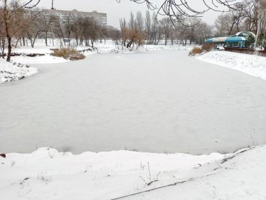 Bir park gölünün manzarası Epifani buzlarının içinde bir buz kabuğuyla bağlı..
