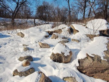 Kıyı Dinyeper kayalarından oluşan bir panorama parlak buz gibi güneşin altında kar örtüsüyle kaplı..