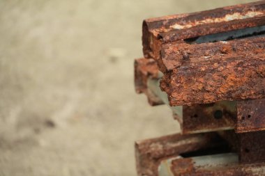 Paslı metal kirişler, sert beton yüzeyde aşınma gösteriyor.