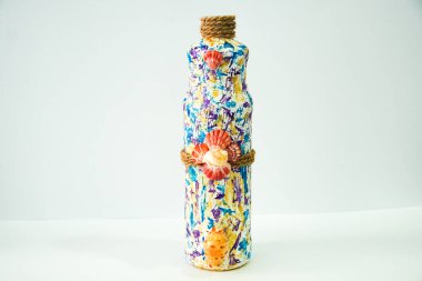 Bu göz alıcı şişe, büyüleyici bir deniz kabuğu kümesi ve kırsal halatla geliştirilmiş, farklı renklerde canlı ve soyut bir tasarıma sahip..