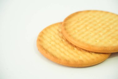 Bu detaylı yakın çekim iki altın yuvarlak bisküvinin davetkar dokusunu vurguluyor. Basit ikramları ya da atıştırmalıkları çekici detaylarla sergilemek için mükemmel..