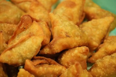 Bu yakın çekim gösterileri, taze kızarmış, altın sarısı samosaların çıtır çıtır dokusunu ve leziz görünümünü vurguluyor. Gıda ile ilgili projeler için mükemmel..