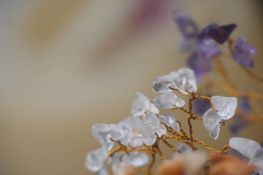 Dekoratif mücevher ağacının küçük, parlak kuvars parçacıkları içeren kusursuz bir yakın çekimi. Altın tel dallar zarif ve saf bir estetik yaratıyor. Huzurlu bir ortam için mükemmel..