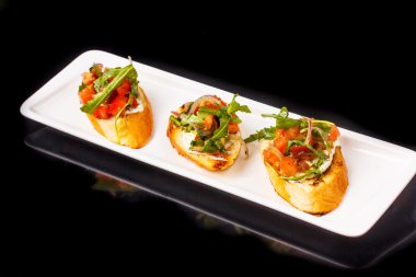 Bruschetta domates, zeytin yağı, roka ve krem peynir bir bagu üzerinde