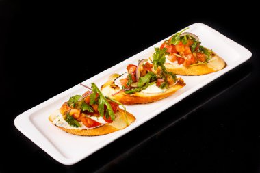 Bruschetta domates, zeytin yağı, roka ve krem peynir bir bagu üzerinde