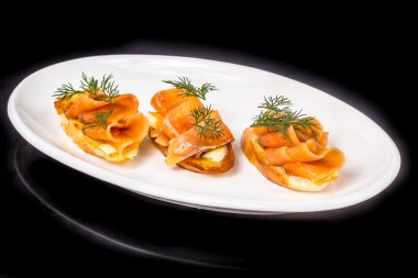 Tuzlanmış somon sandviç plaka üzerinde yalan.