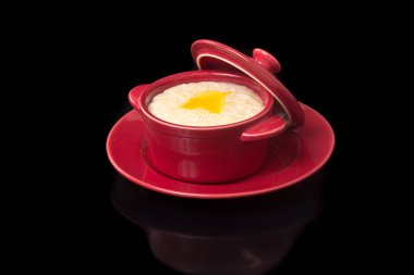 Seramik bir tencerede süt ile pişmiş yulaf ezmesi.