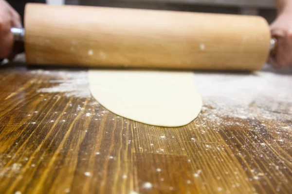 Preparation of the dough. Cook rolls out the dough on the Board. — Stock Photo, Image