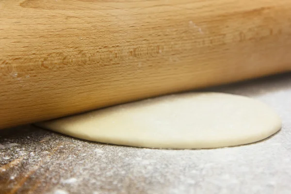 Zubereitung des Teiges. Koch rollt den Teig auf dem Brett aus. — Stockfoto