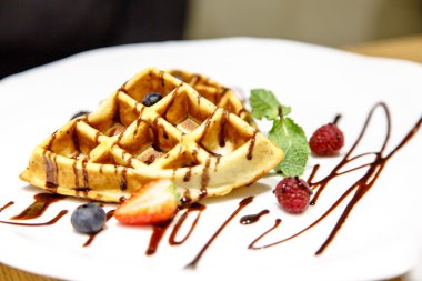 Viyana waffle üzerine çikolata sosu meyveleri ile drizzled bir