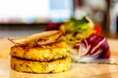 Hashbrown patates köfteleri tabakta salatayla servis edilir. Büyük ölçüde.