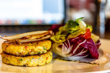 Hashbrown patates köfteleri tabakta salatayla servis edilir. Büyük ölçüde.