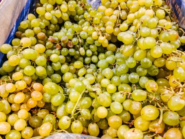 Mağazadaki bir kutuda bir sürü üzüm var.