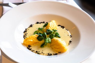 Peynir soslu Polenta bir restoranda masanın üstünde.
