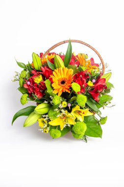 Sarı papatyalı bir sepet çiçek, beyaz arka planda kırmızı çiçekler ve zambaklar.