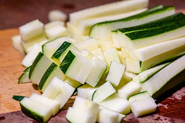 The cook cuts the zucchini into small cubes