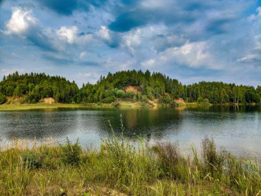 Yaz. Güneşli. Çam ormanlarının arasında bir orman gölü.