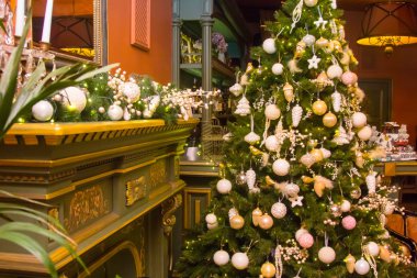 Şöminenin önünde baubles ile süslenen Noel ağacı.