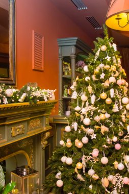 Şöminenin önünde baubles ile süslenen Noel ağacı.